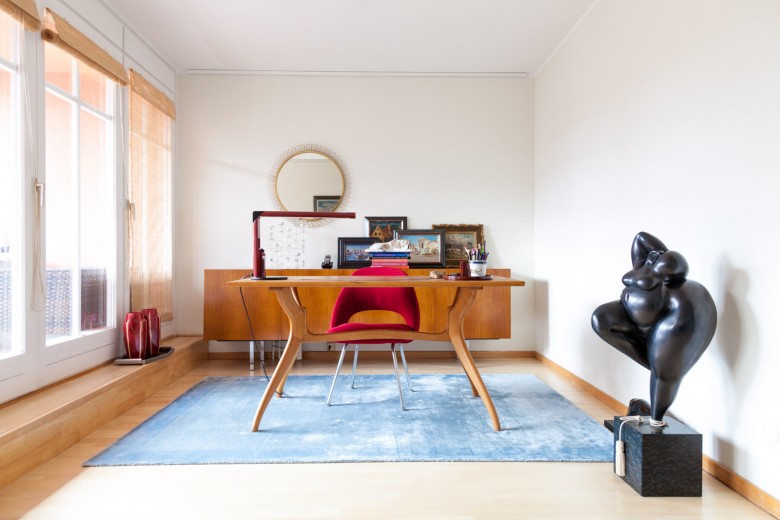 Foto Jordana Schramm Nahaufnahme Interior Wohnung Elena Schmuschkowitz. Arbeitszimmer mit rotem Stuhl. Im Vordergrund Skulptur einer fülligenSchönen.