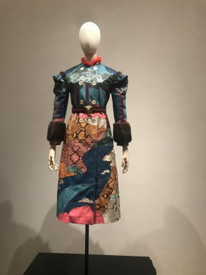 Gucci Museum. Buntes Kleid auf Scahufernsteqpuppe. Pelzbesatz an den Armen. Patchworklook .