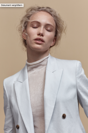 Foto: Filippa K Model in weissem Sakko mit cremfabenenem zarten Rollkragenpullover von Filippa K