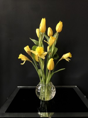 Foto/Styling: Nikolas Feireiss Gelbe Tulpen und Narzissen in kleiner runder Glasvase mit Gravur.