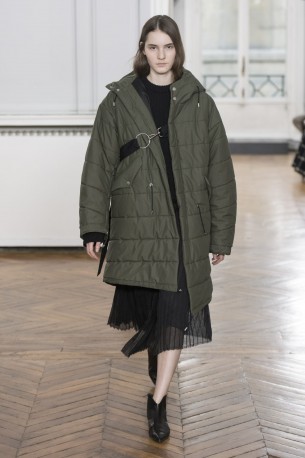 Gauchère Herbst Winter 2018 Model in weitem olivgrünen Mantel, darunter transparentes schwarzes Kleid.