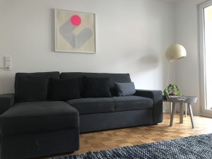 Sofa mit Beistelltisch und 60er Jahre Lampe.