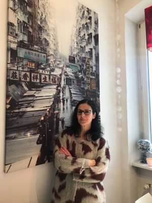 Nadja Al-Chalabi vor Plakat mit asiatischer Stadt.